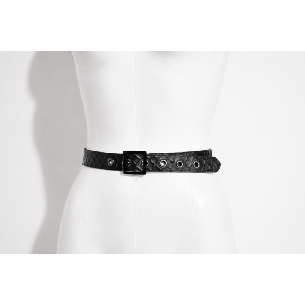 Latex Fashion by Vex A black textured belt with a square buckle and metal eyelets is fastened around the waist of a white mannequin torso against a plain background.